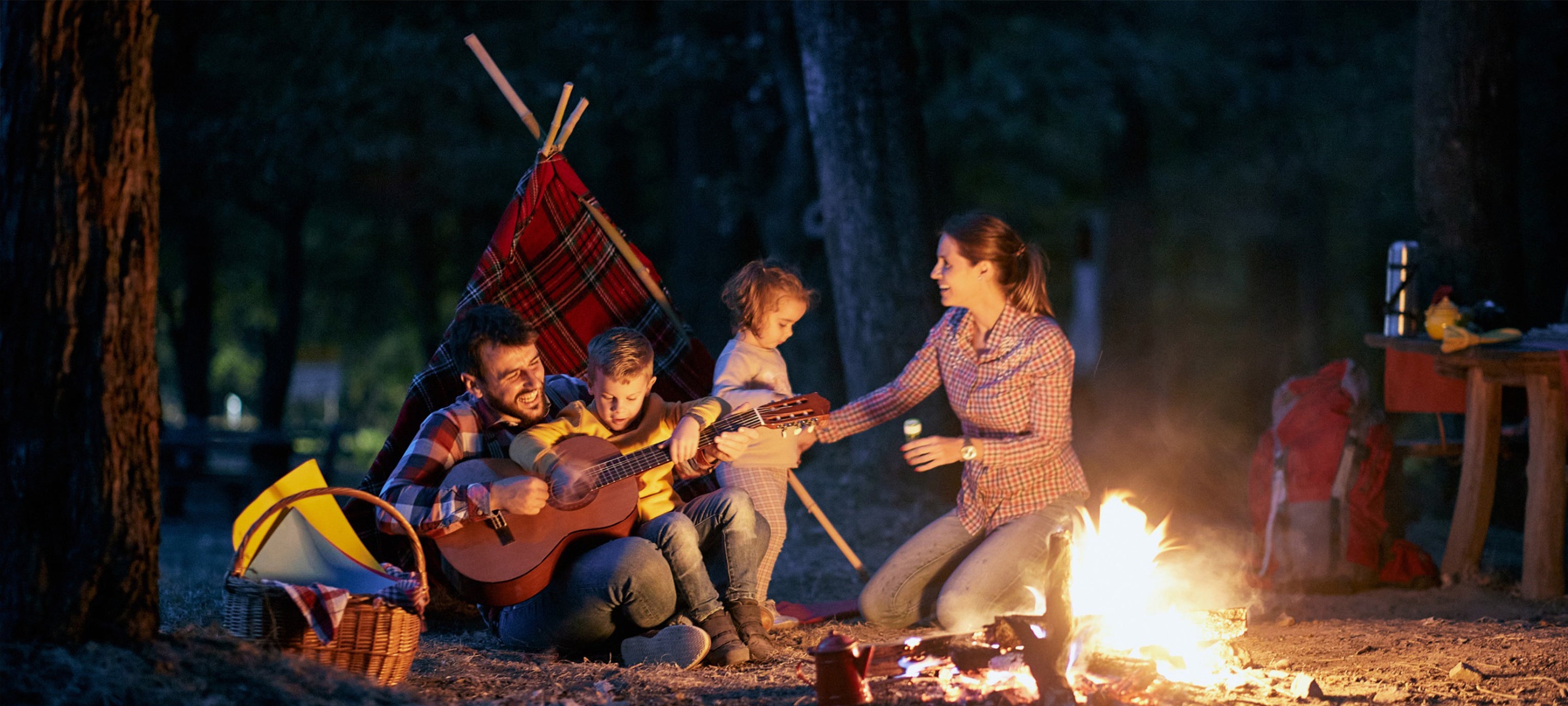 family of five camping with a bonfire